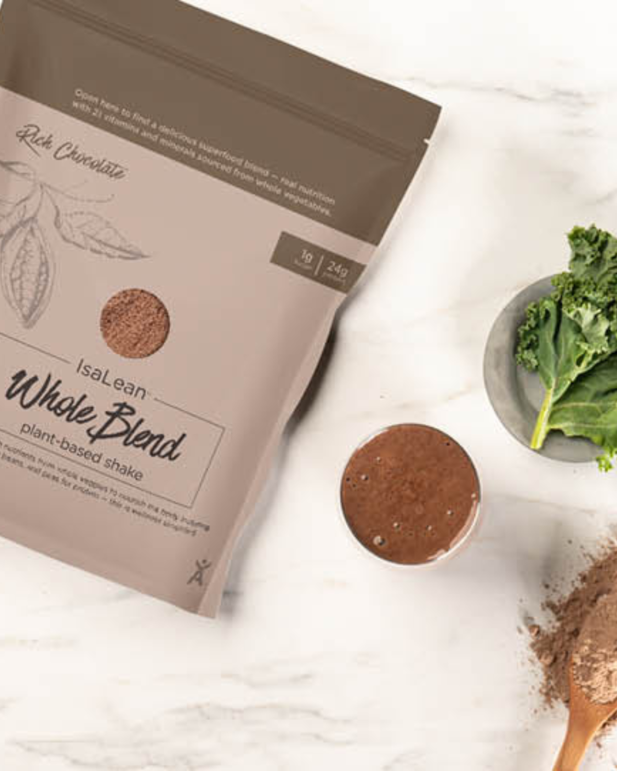 The Ultimate Meal Solution (1) Creamy IsaLean Shake in a glass, flanked by an assortment of vibrant superfoods and a scoop of powdered blend.